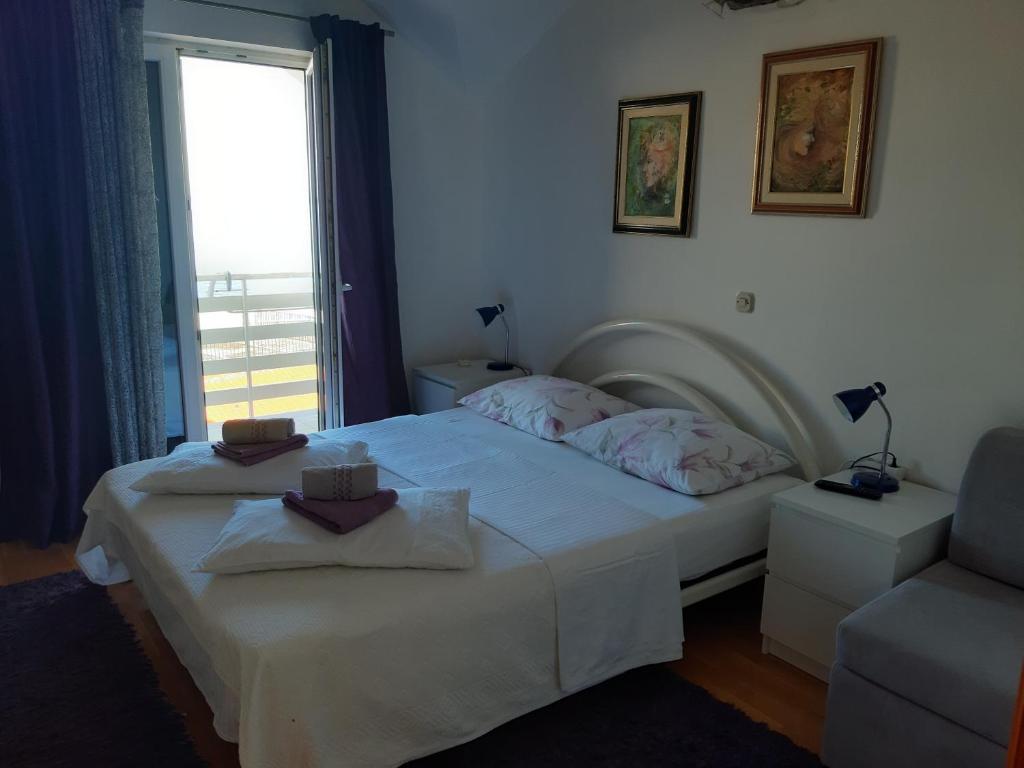 格拉达茨Apartments by the sea Gradac, Makarska - 15642的卧室配有床、椅子和窗户。