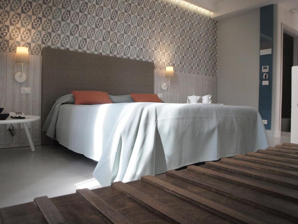 马纳罗拉卡迪安德烈酒店的一间卧室配有一张床铺,床上铺有白色毯子