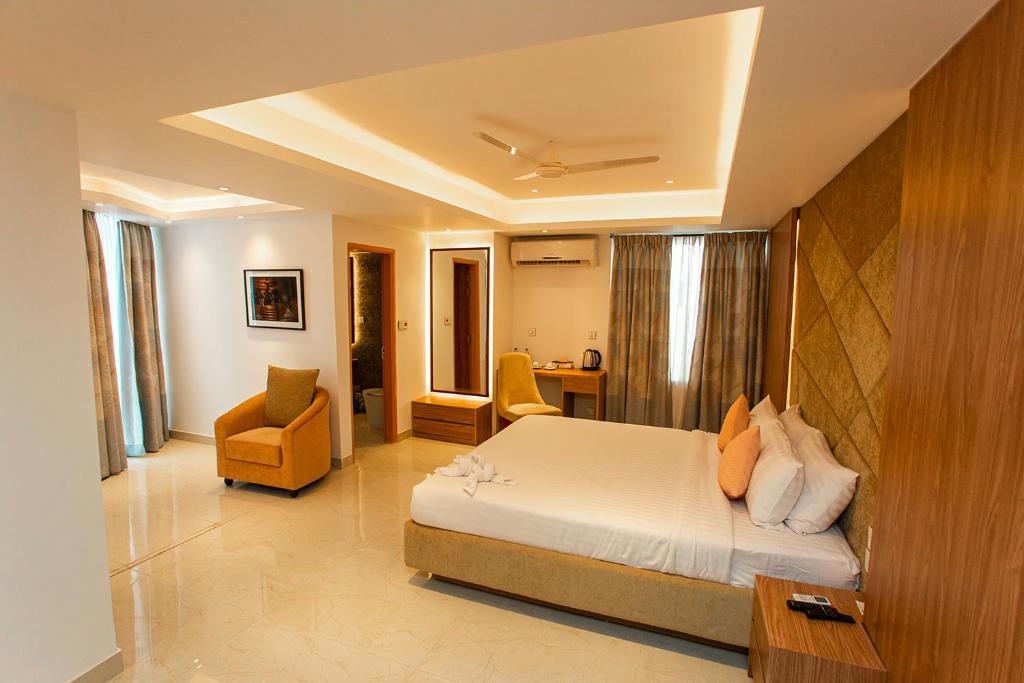 拉杰沙希Royal Raj Hotel的卧室配有一张床、一张桌子和椅子