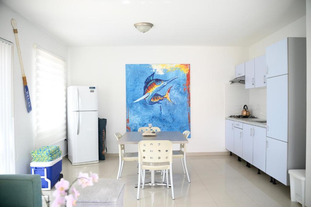 努尔德Beach Homes Aruba的厨房配有桌子,墙上挂有绘画作品