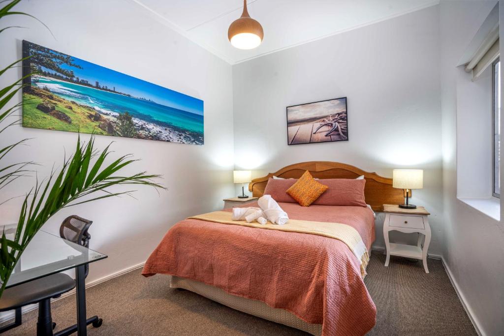 奥兰治One-Bedroom Apartment on Summer的一间卧室配有一张床、两盏灯和一棵植物