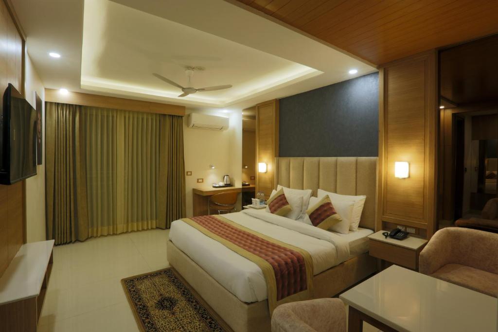 古尔冈Hotel Sakura by Maps的酒店客房设有一张大床和一张沙发。
