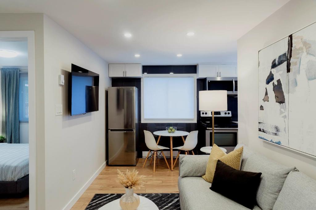 渥太华Modern, Luxurious Apartment near Downtown Ottawa的厨房以及带沙发和桌子的客厅。