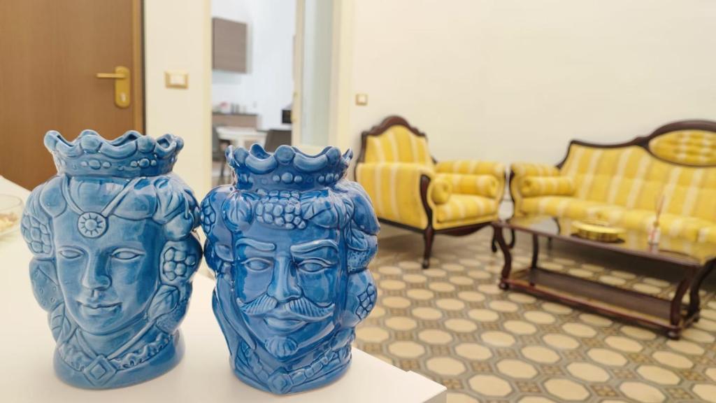 卡塔尼亚DUHOME apartment in the heart of Catania的两个蓝色花瓶坐在一个房间里桌子上