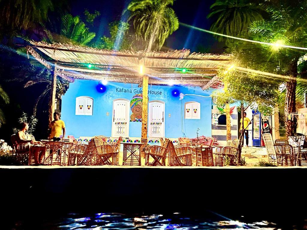 阿斯旺Kafana Guest House Nile View的蓝色建筑前的一组桌椅