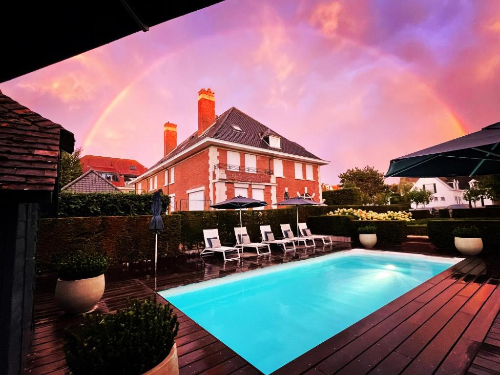 德哈恩Romantik B&B Zonnehuis的一座带彩虹的房屋前的游泳池