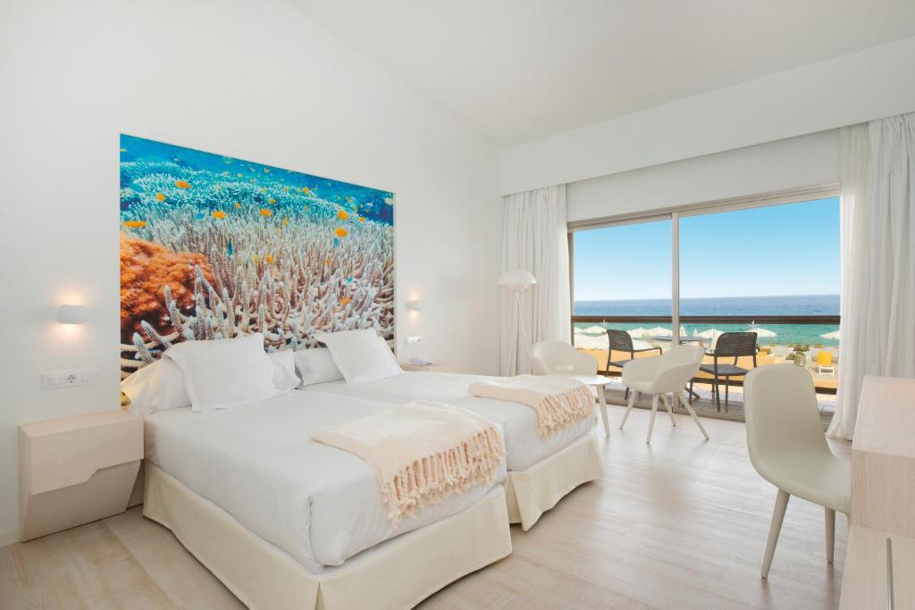 莫罗德哈布雷Iberostar Selection Fuerteventura Palace的一间卧室配有一张床,并画着海洋