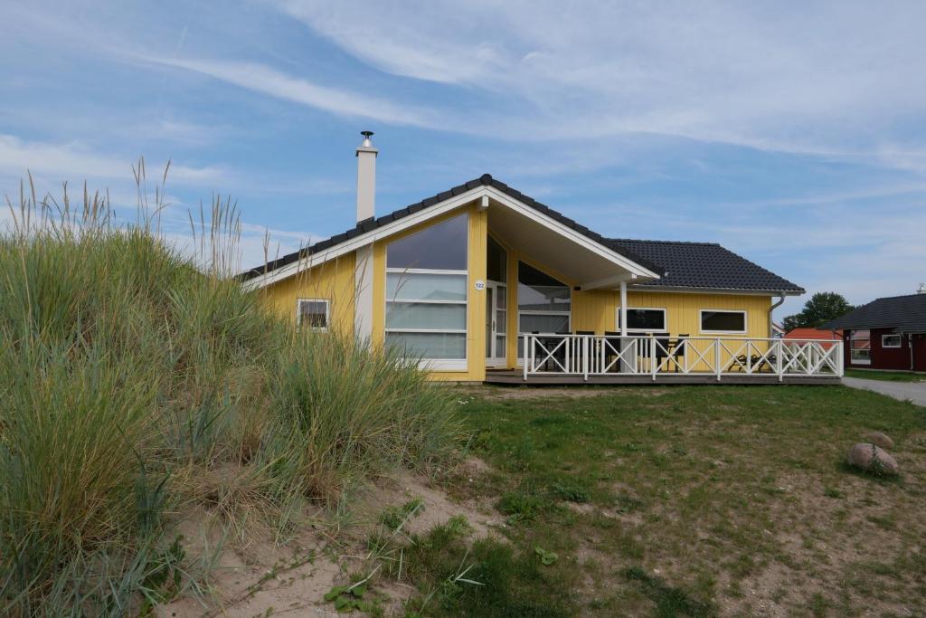 格罗森布罗德Resort 2 Ferienhaus Typ D 122的海滩上带门廊的黄色房子