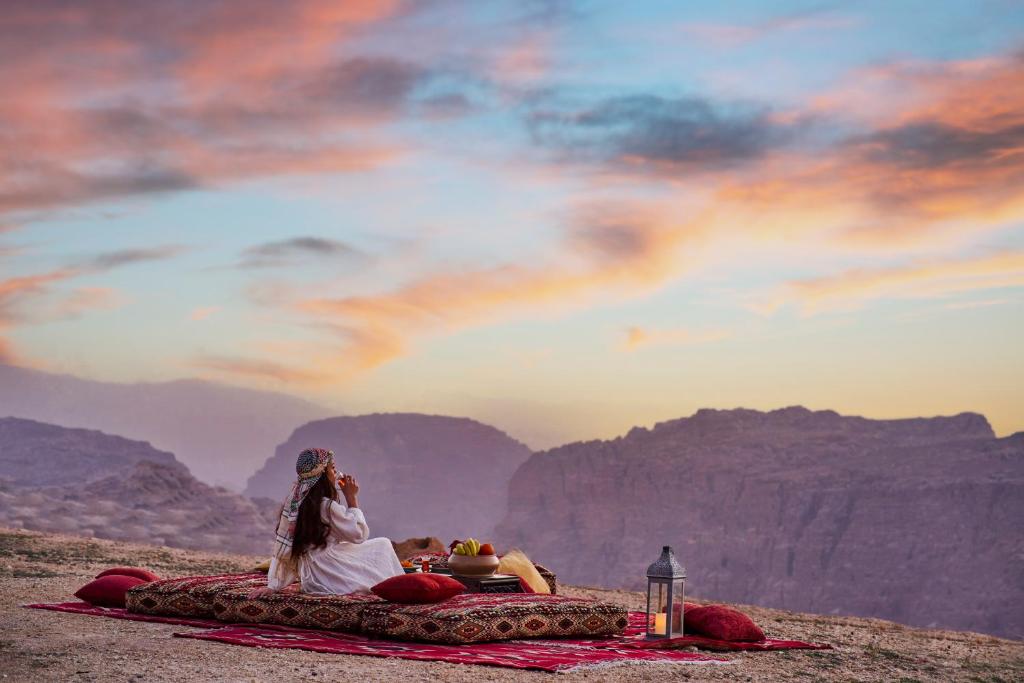瓦迪穆萨Grand Mercure Petra的一对夫妇躺在山里的一个毯子上