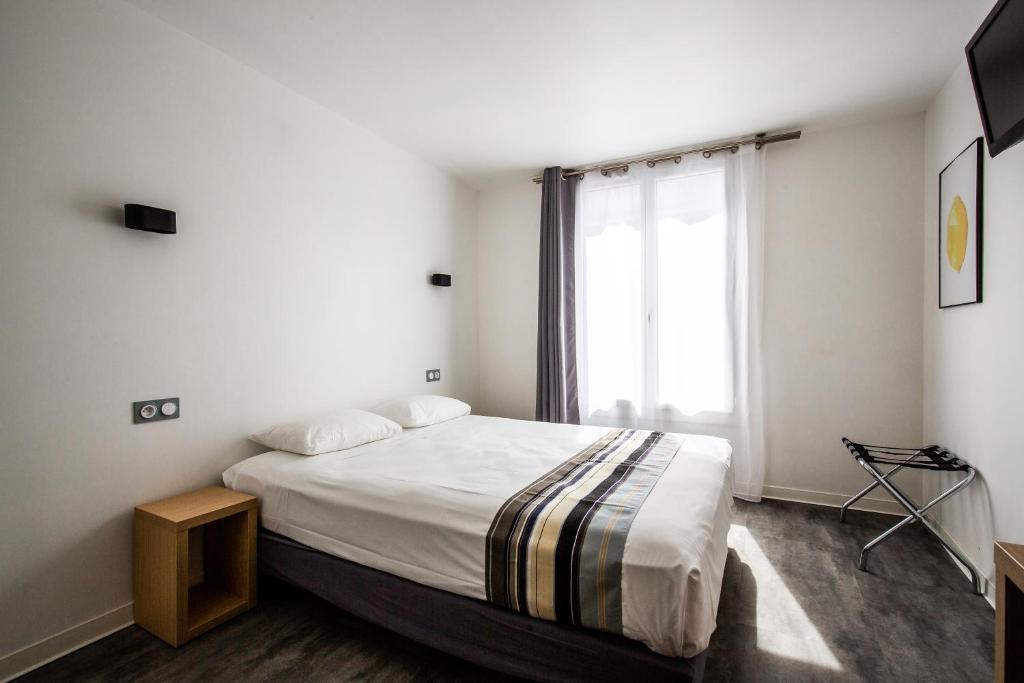 佩皮尼昂Hôtel PB - Paris-Barcelone的一间卧室设有一张大床和一个窗户。
