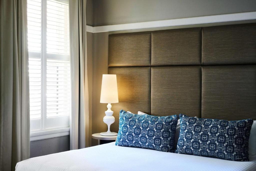 堪培拉堪培拉库拉降酒店的一间卧室配有一张带大床头板的床
