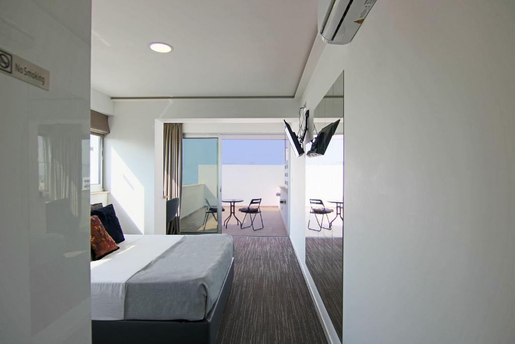 尼科西亚Phaedrus Living: Luxury Suite Nicosia 503的一间卧室配有一张床,阳台配有桌子