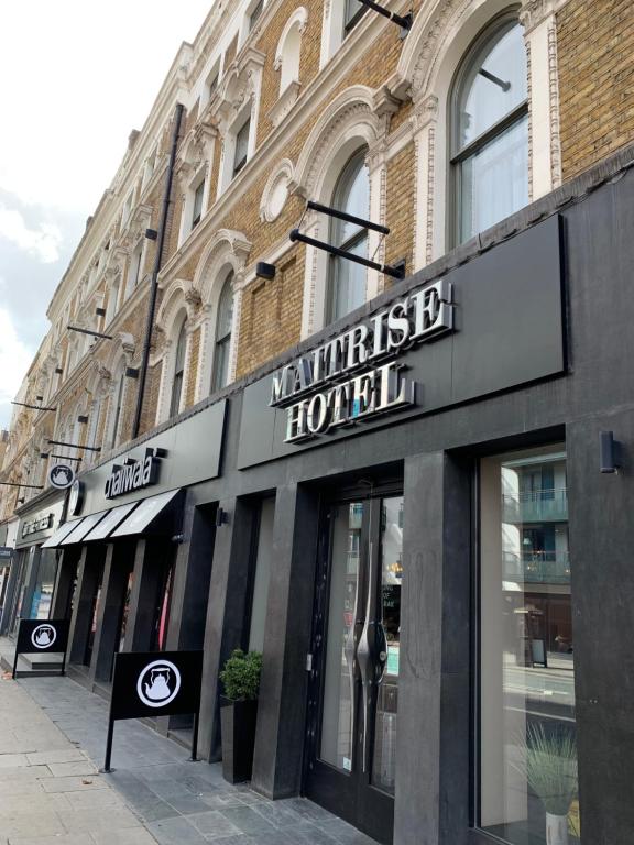 伦敦Maitrise Hotel Maida Vale - London的建筑物前面的商店,上面有标志