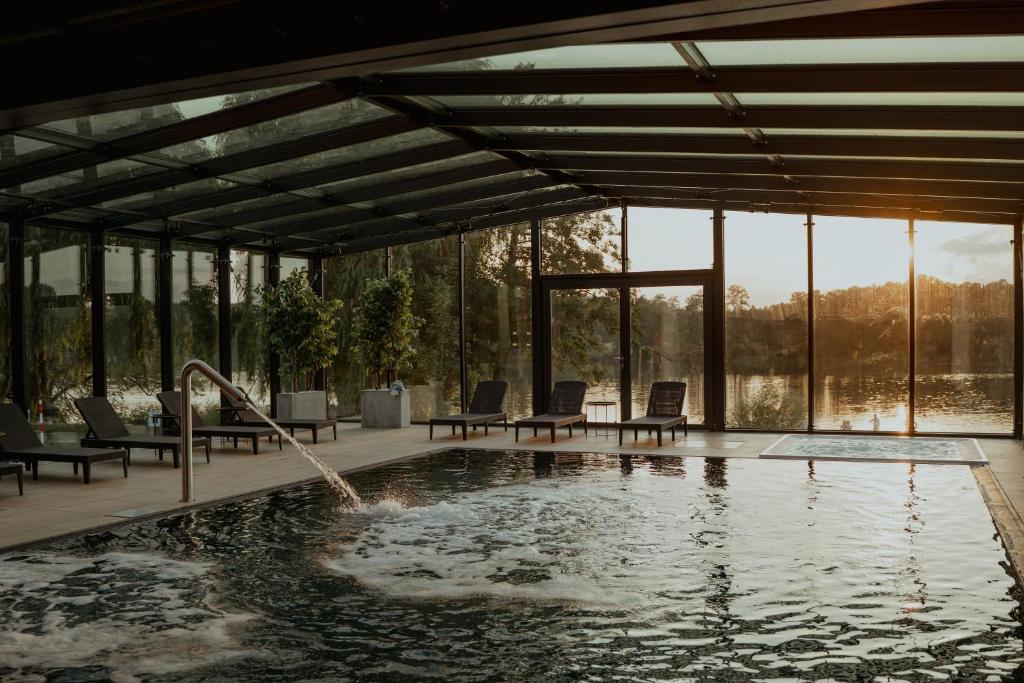Kwilcz欧兰迪亚酒店的一个带椅子的游泳池以及一个喷泉
