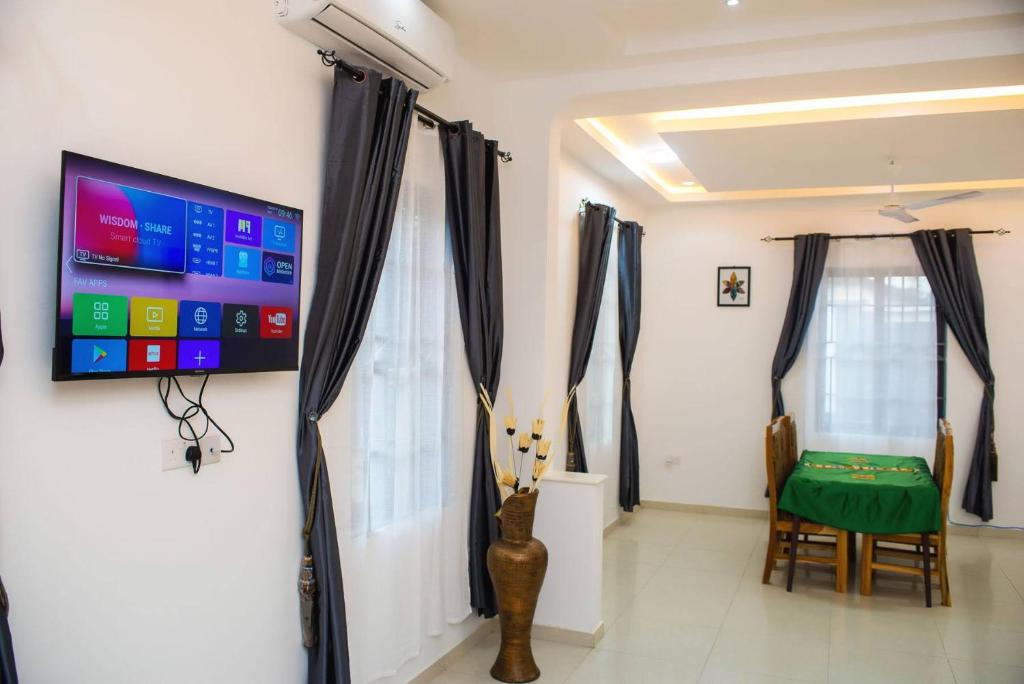 阿克拉William Ofori-Atta Fie的墙上配有平面电视的房间