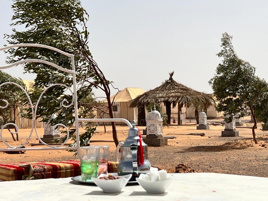 梅尔祖卡Merzouga Camp & Desert Activities的桌子上放着饮料和食物