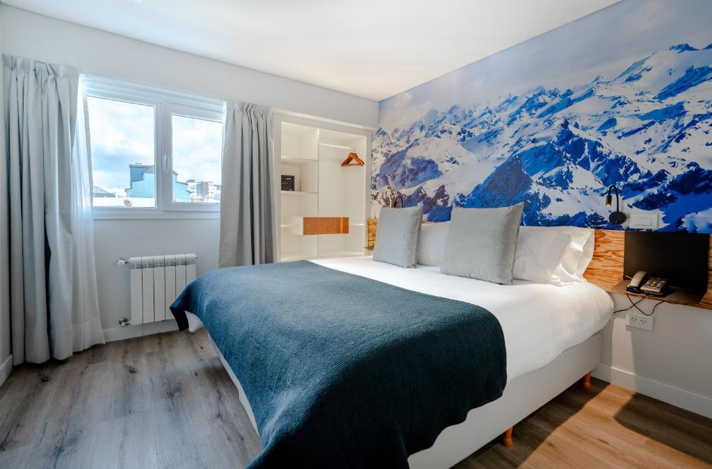 乌斯怀亚Cilene del Fuego Suites & Spa的一间卧室配有一张大床和山壁画