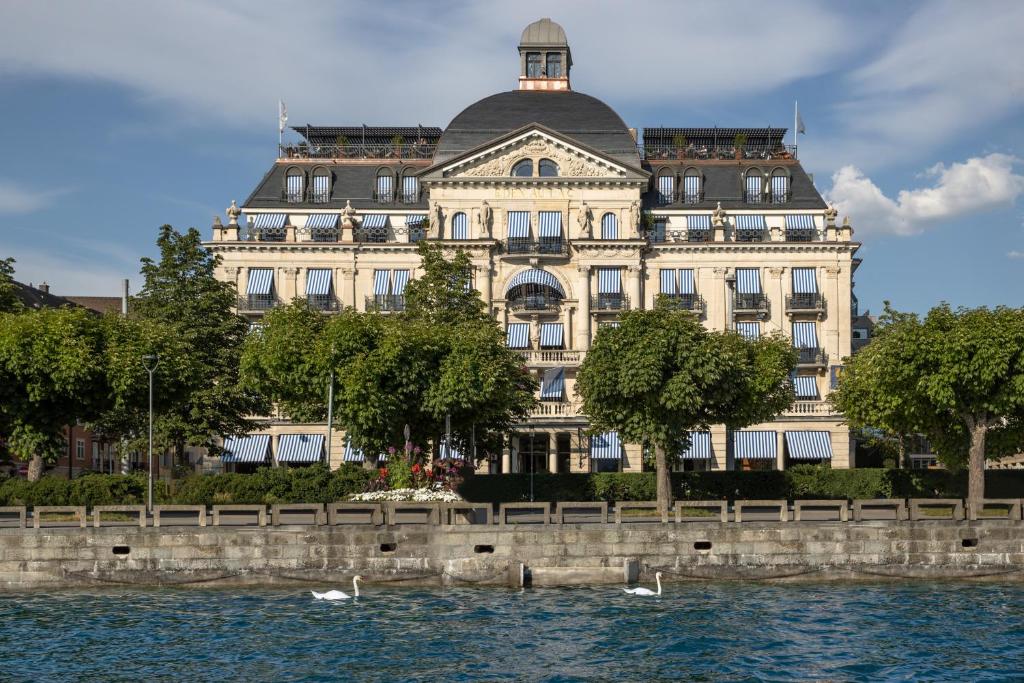苏黎世La Réserve Eden au Lac Zurich的靠近水体的大建筑