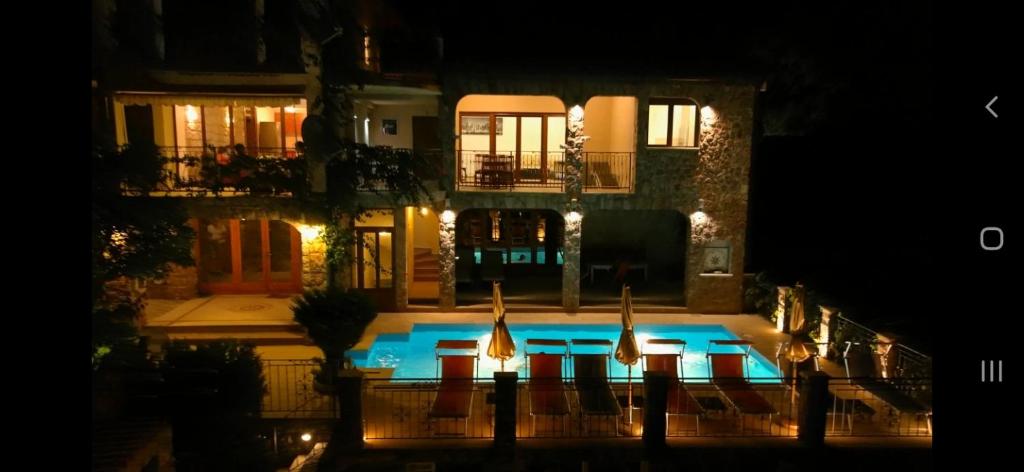 布德瓦Apartments Villa Čučuk的夜间在房子前面的游泳池