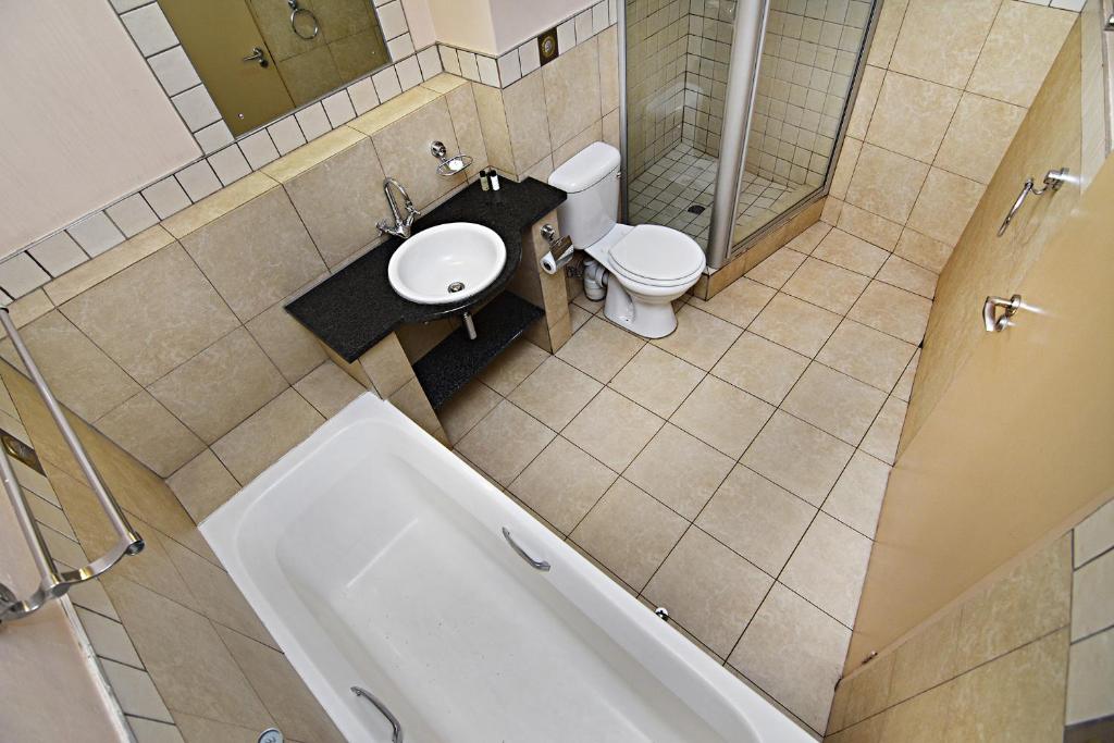 约翰内斯堡The Gold Hut的浴室配有卫生间、盥洗盆和浴缸。