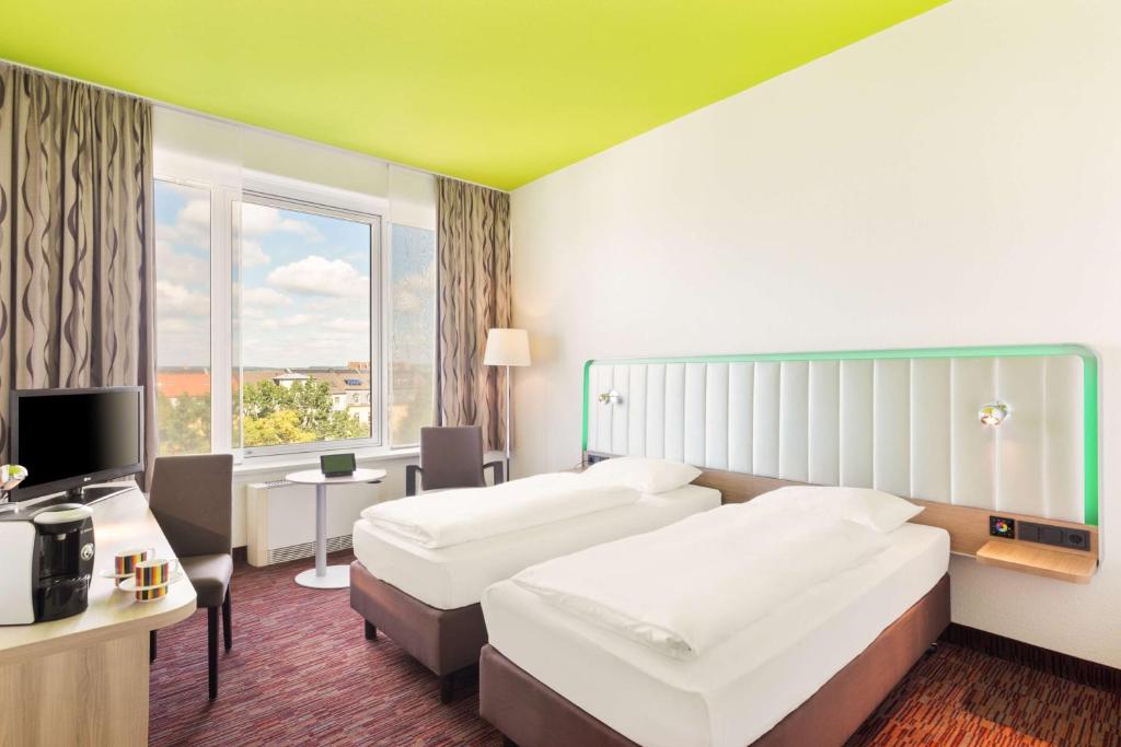 德累斯顿德勒斯等雷迪森酒店公园店的酒店客房设有两张床和电视。