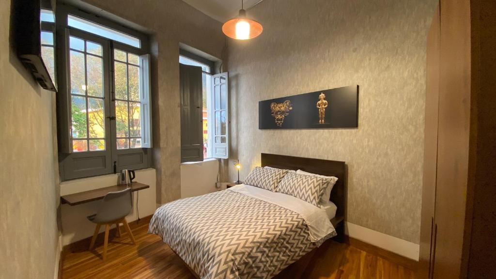 波哥大REPUBLICANA CASA HOSTAL - HABITACION 5 TAIRONA的卧室配有一张床、一张书桌和窗户。