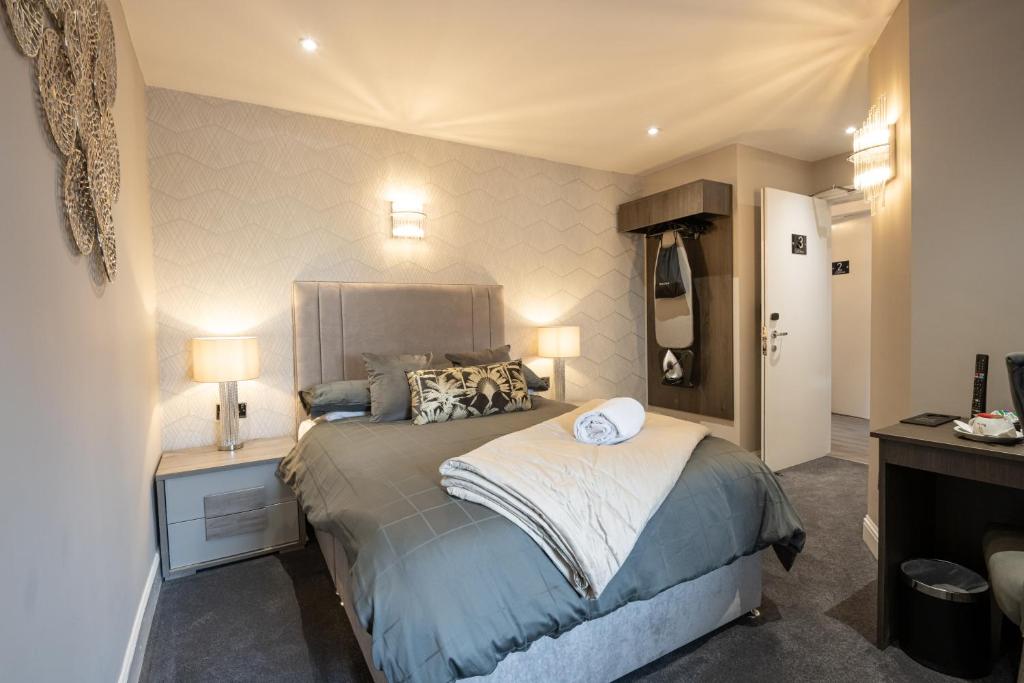 邓迪堡垒酒店的一间卧室配有一张床和一个带两盏灯的床头柜。