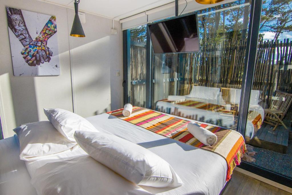 皮奇勒姆Quisquito Lodge & Spa - Punta de Lobos - Tina 24 Hrs的一间卧室设有一张床,享有阳台的景色