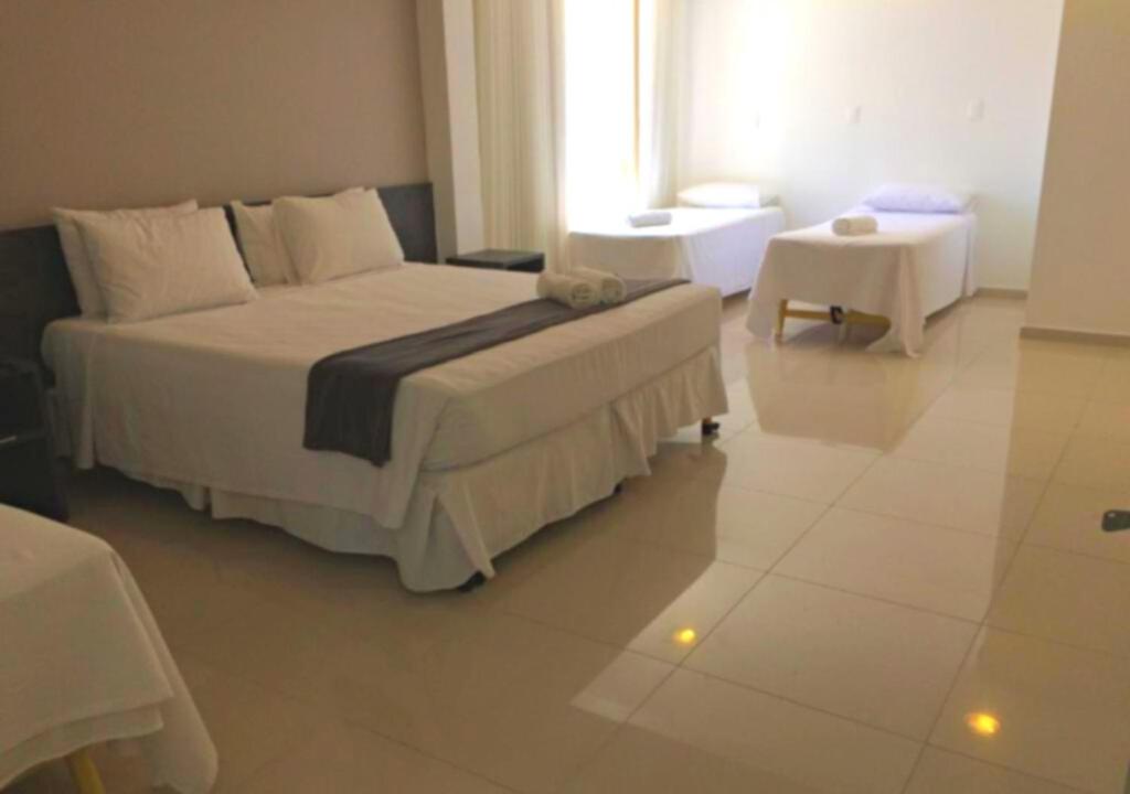 累西腓Scenarium Hotel的卧室配有一张白色的大床和一张桌子