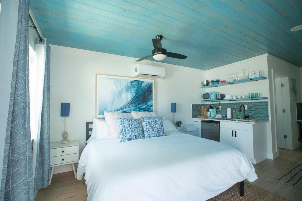 萨拉索塔Casa Limonada Boutique Motel的卧室配有白色的床和蓝色的天花板