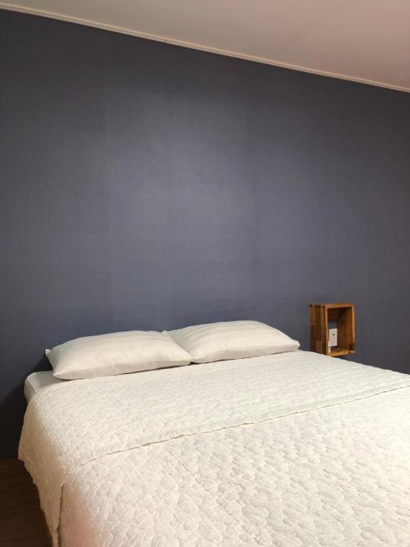 木浦市Jo Eun Jip Guesthouse的卧室配有白色床和蓝色墙壁