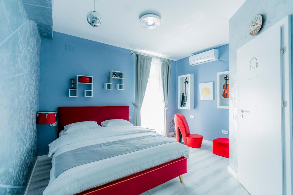 奥拉迪亚Catharsis House - self check in and self checkout的蓝色卧室,配有床和红色床头板