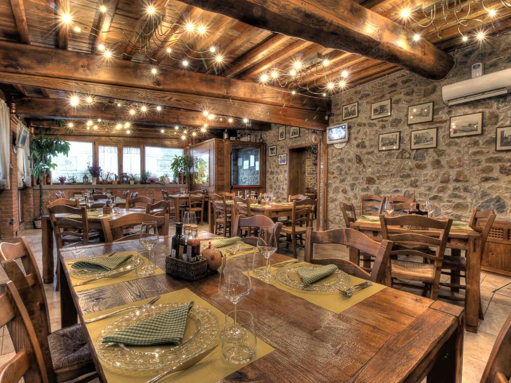 阿雷佐朱利亚拉罗坎达旅馆的用餐室配有木桌和椅子