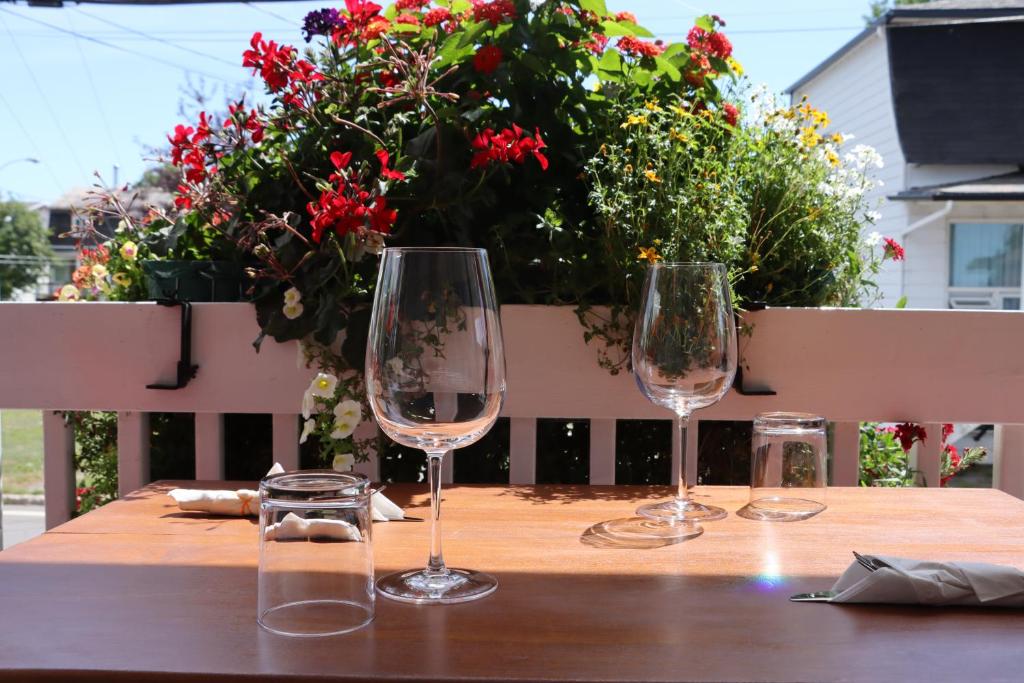L'islet Sur MerGîte du Pionnier的三杯酒杯坐在木桌旁,摆放着鲜花
