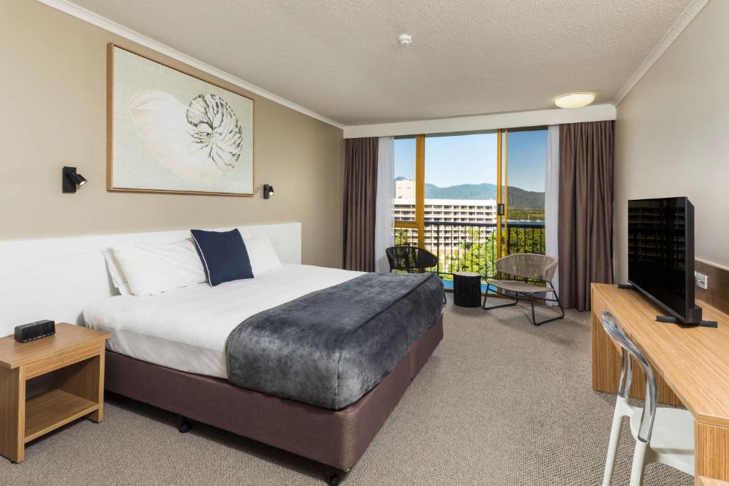凯恩斯凯恩斯太平洋大酒店的酒店客房设有床、电视和阳台。
