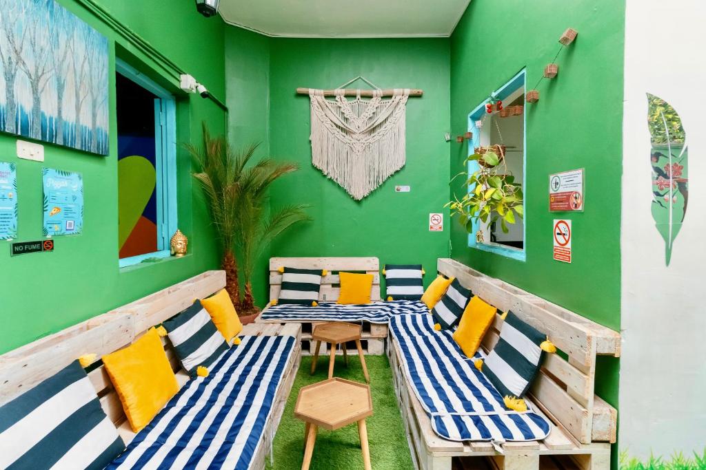 利马The Secret Garden Hostel的绿墙客房内的桌椅