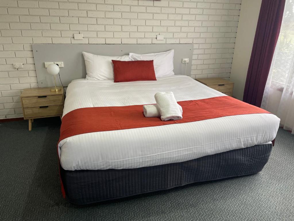 沃勒格尔沃拉格尔美景汽车旅馆的一间卧室配有一张大床,铺有红白毯子