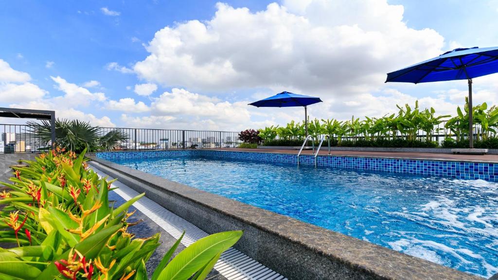 胡志明市DHTS Business Hotel & Apartment的游泳池的顶部设有两把遮阳伞