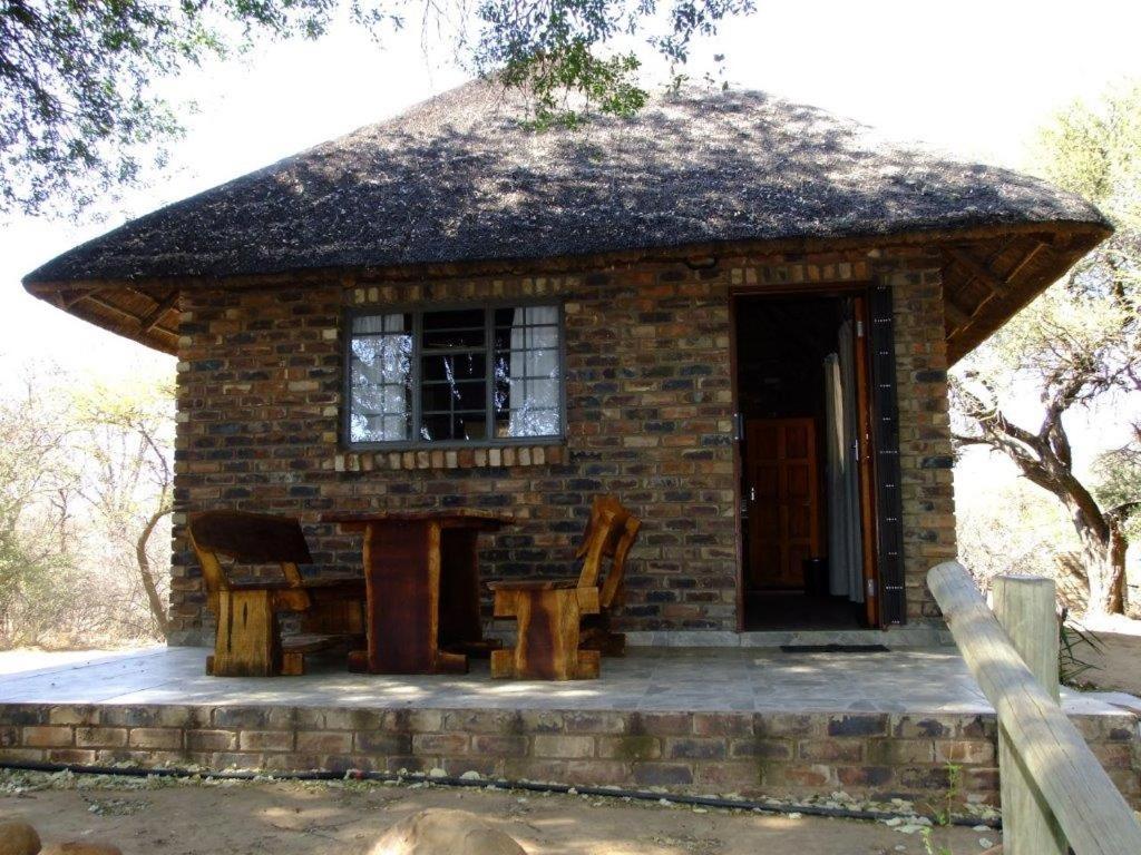Mkolo Hunting and Wildlife的一座配有桌椅的小砖屋