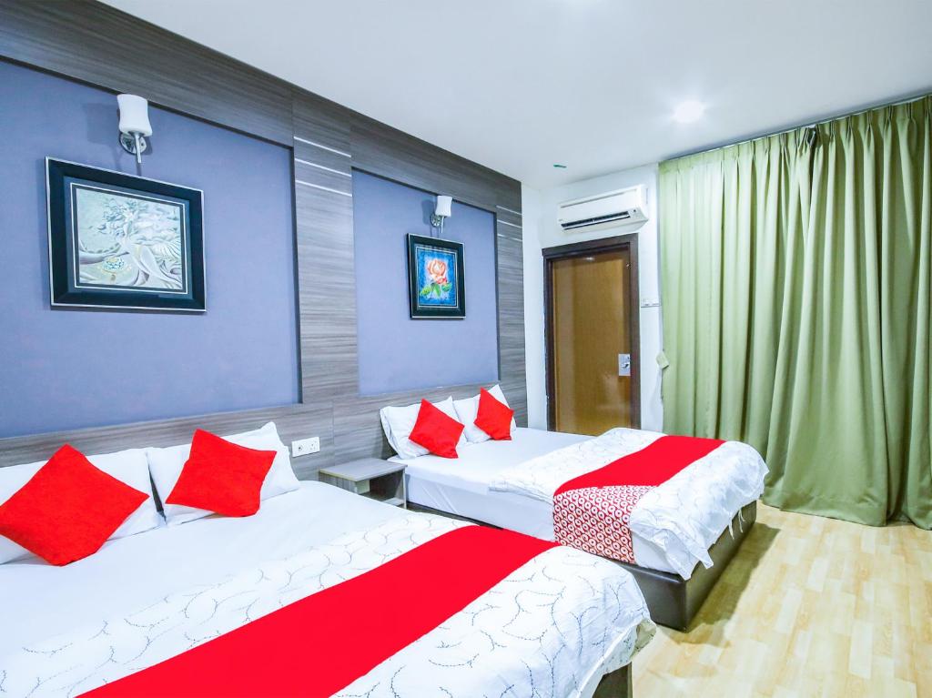 莎阿南Super OYO Capital O 812 Hotel SMC Seksyen 13的一间卧室配有两张带红白色枕头的床
