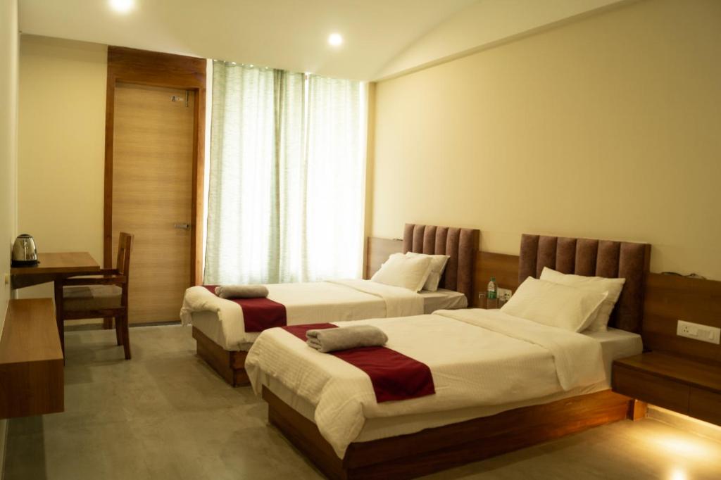 GolāghātChang's Garden & Resort的酒店客房配有两张床和一张书桌