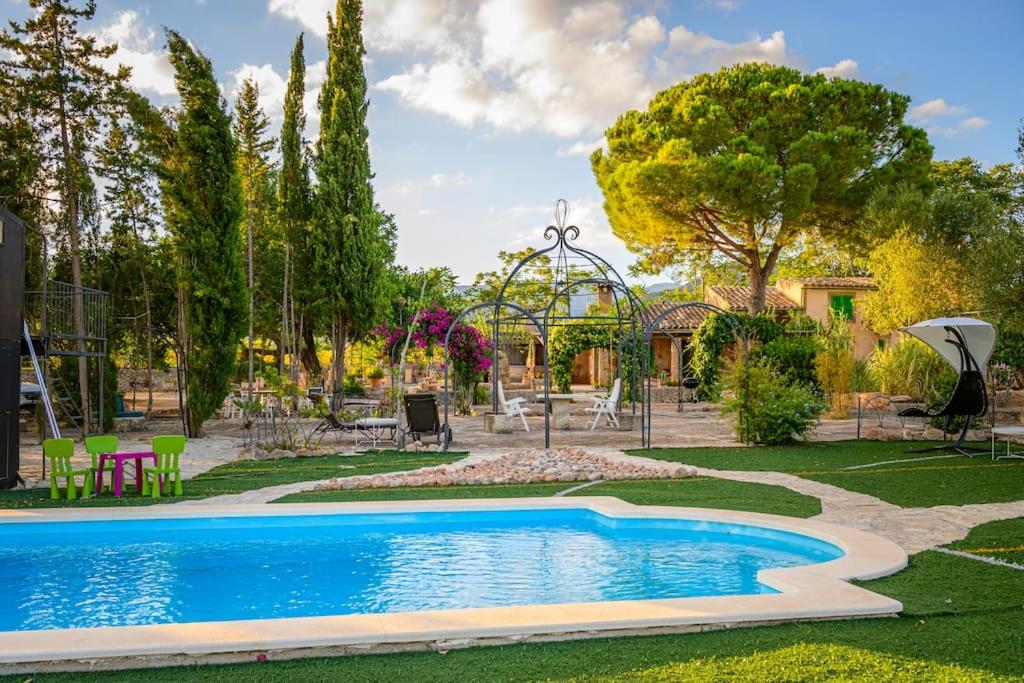 圣马里亚德尔卡米Nice Majorcan country house Sta Maria del Camí by Renthousing的花园内的游泳池,带游乐场