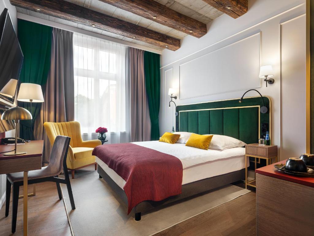 克拉科夫Hotel Golden Queen的一间卧室配有一张床、一张桌子和一把椅子