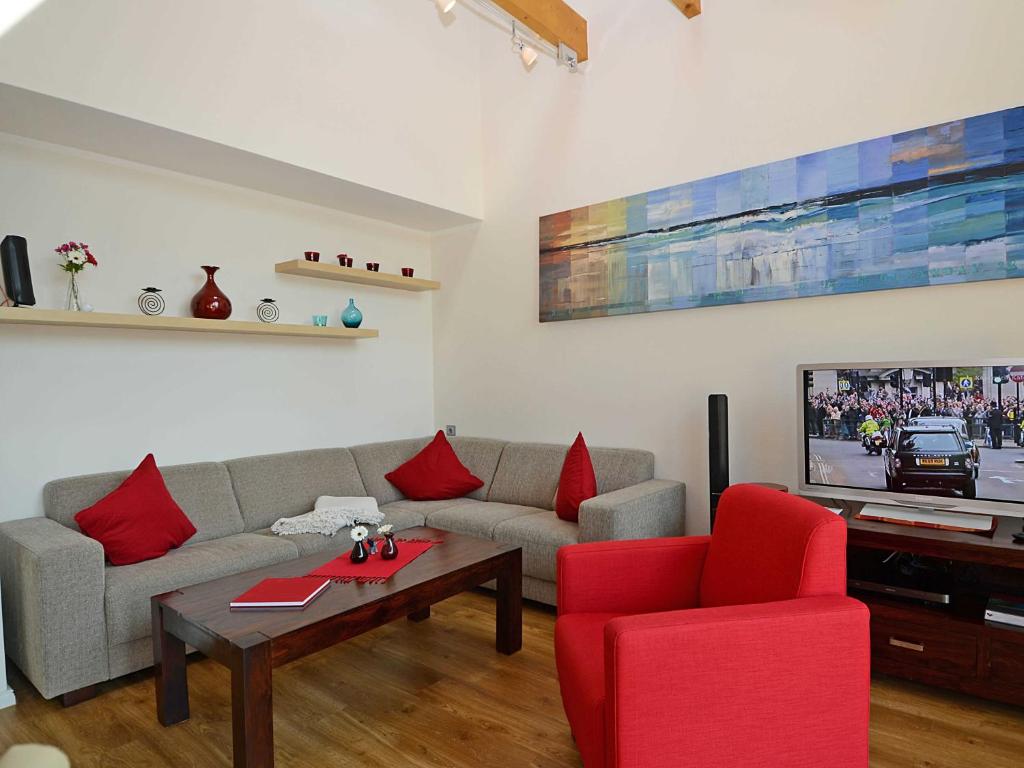 奥斯赛拜-塞林Ferienhaus Luv & Lee - Apt. 01的带沙发和红色椅子的客厅