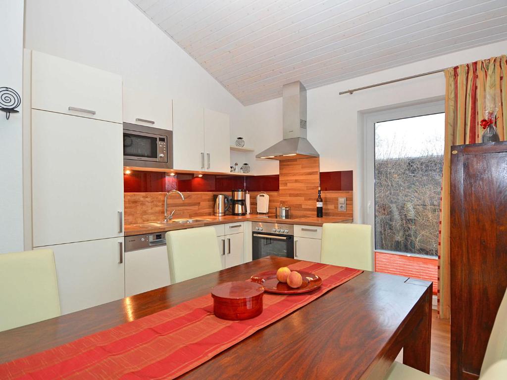 奥斯赛拜-塞林Ferienhaus Luv & Lee - Apt. 02的厨房配有一张桌子,上面放着一碗水果