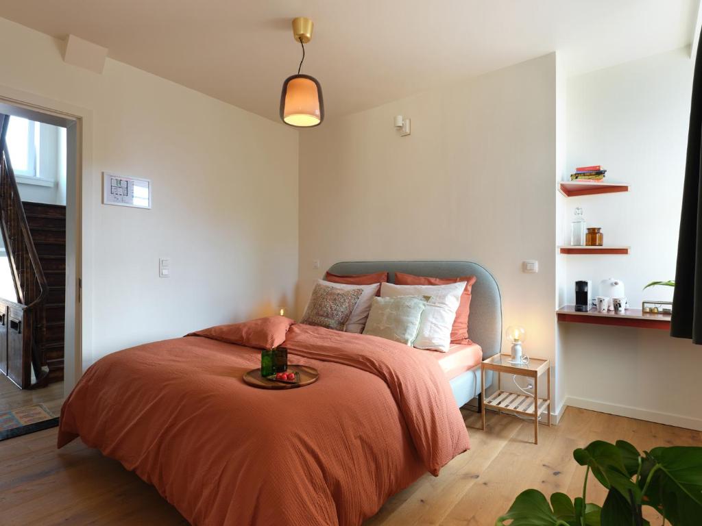 布鲁日Rûte - Bed no Breakfast的一间卧室配有一张带橙色毯子和桌子的床