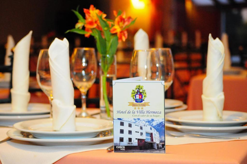 库斯科Hotel De la Villa Hermoza的桌子上摆放着盘子和酒杯的桌子