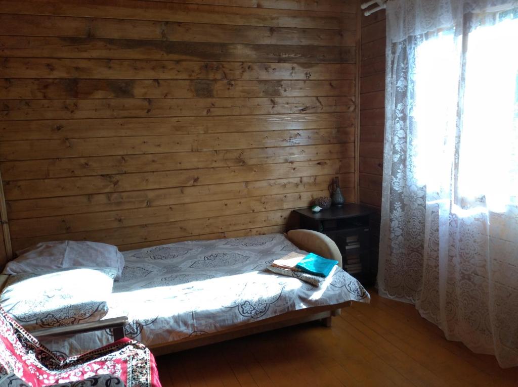新阿丰Семейный домик под ключ у моря в Новом Афоне!的一间卧室设有一张床和木墙