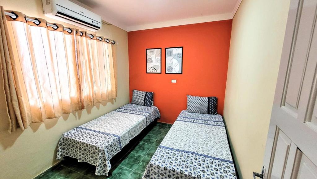 伊波茹卡House Maraca的橙色墙壁的客房内的两张床