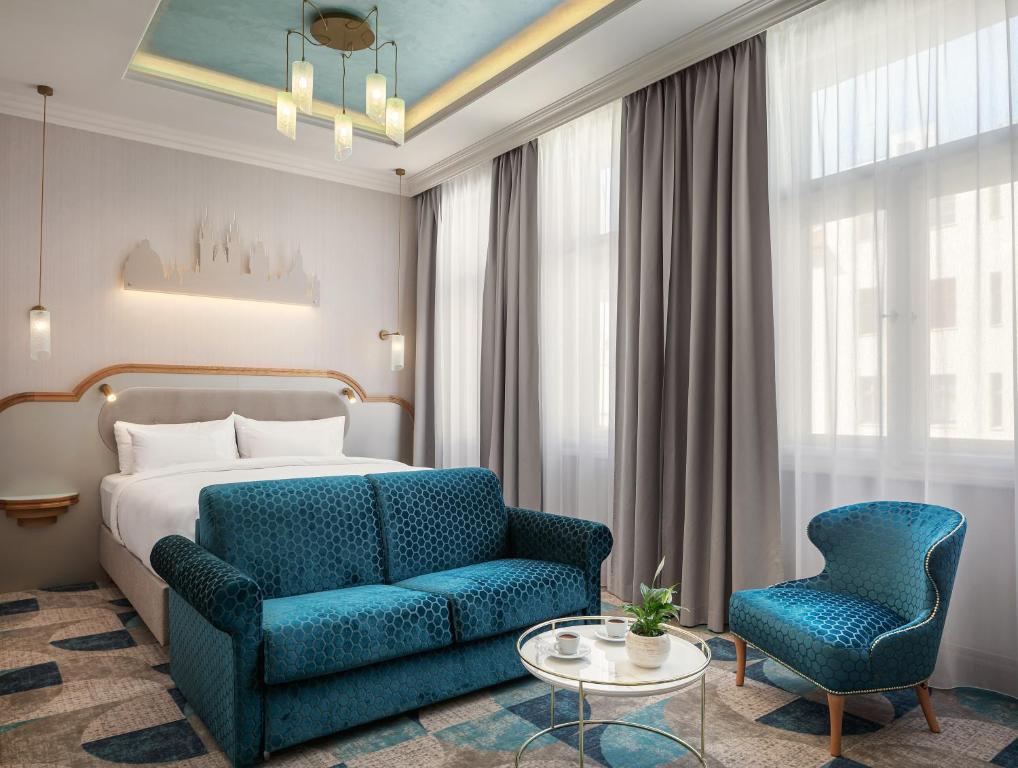 布拉格Allure Hotel Prague的酒店客房,配有一张床和一张蓝色椅子